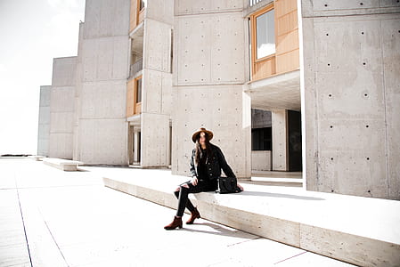 woman sitting on beige concrete bench outdoor during daytime thumbnail