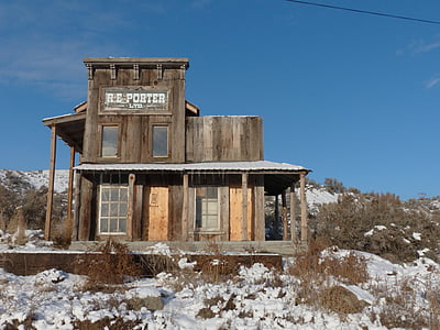brown wooden 2-storey house surrounded by snow thumbnail