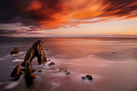 orange clouds calm sea during sunset thumbnail