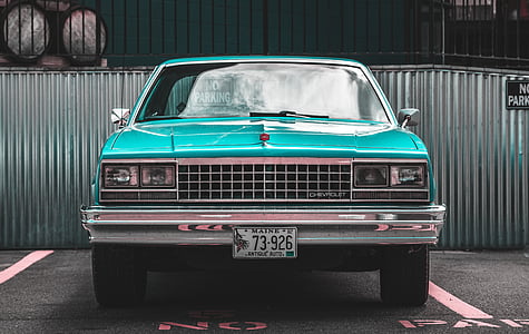 blue vehicle parked near gray wall at daytime thumbnail