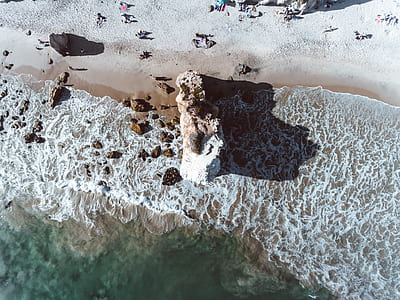 aerial photography of rock near sea at daytime thumbnail