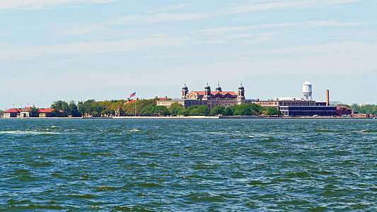 Ellis Island under a light cloud covered sky on a beautiful Summer day around New York harbor. thumbnail