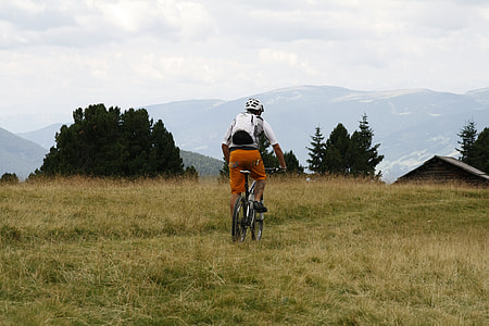 person cycling through grass plain thumbnail