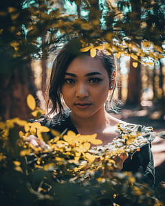 focus photo of woman in front of leaves thumbnail