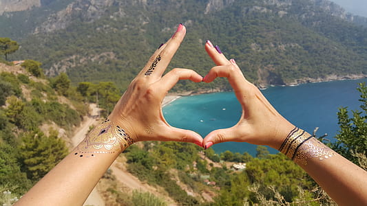 human forming heart with cal sea during daytime thumbnail