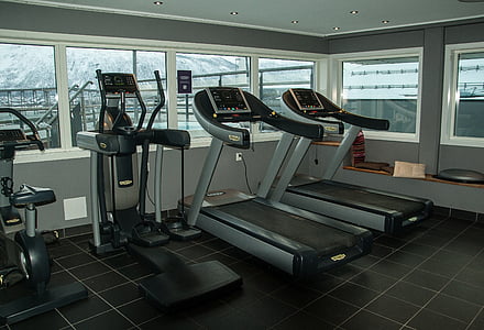 two gray-and-black treadmill besides of black and gray elliptical trainers thumbnail