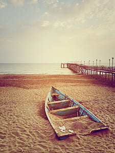gray and brown clinker boat on seashore thumbnail