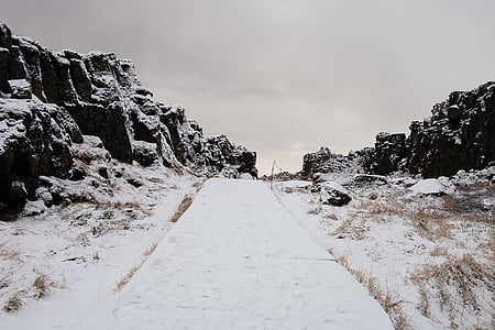 snow covered road between mountains during daytime thumbnail
