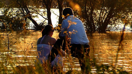 woman sitting beside man near body of water thumbnail