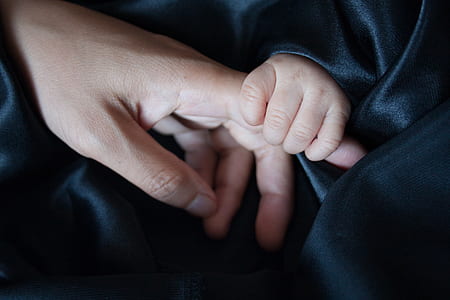baby holding person's finger thumbnail