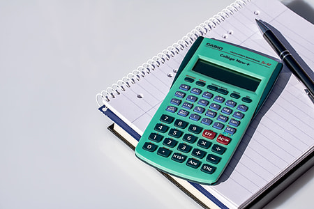green Casio calculator on white notebook beside pen thumbnail