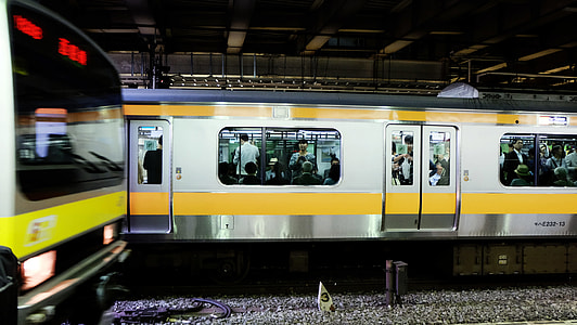 people riding in gray and yellow train thumbnail