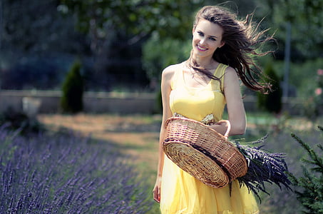 woman in yellow sleeveless dress carrying brown wicker basket thumbnail
