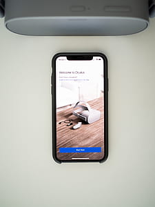 black smartphone beside gray speaker thumbnail