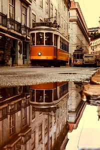 orange and grey train reflection on body of water thumbnail