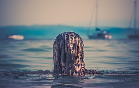 woman with brown hair swimming under the sea thumbnail
