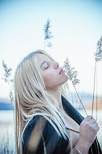woman closing her eyes holding leaves thumbnail