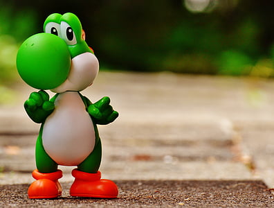 Yoshi toy standing on pavement thumbnail
