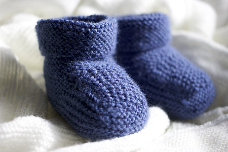 pair of blue bootees on white textile thumbnail