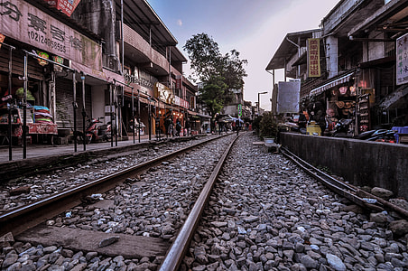 train rail surrounded with houses and store buildings thumbnail