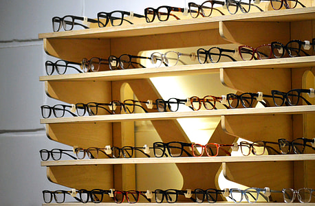 clear eyeglasses on brown wooden shelves thumbnail