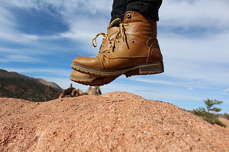 person wearing brown leather cap-toe chunky heel combat boots jumping over brown soil thumbnail
