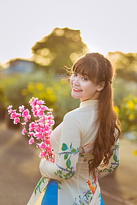 woman holding pink petaled flower thumbnail