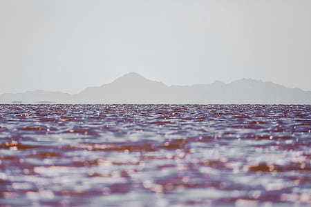 close up photo of body of water with mountain silhouette background thumbnail