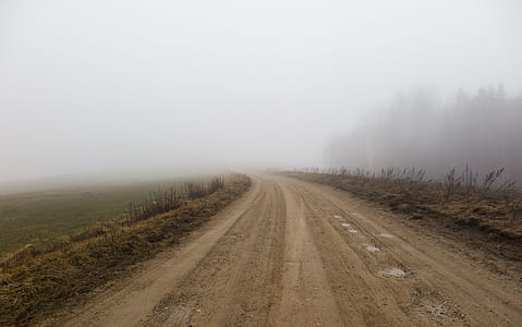 brown rough road in middle of grass field thumbnail