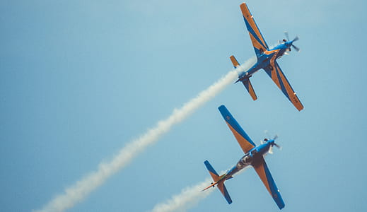two blue-and-brown airplanes at the sky during day thumbnail
