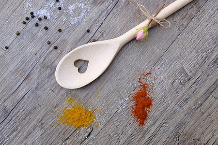 brown wooden heart cut ladle on brown wooden surface beside spices thumbnail