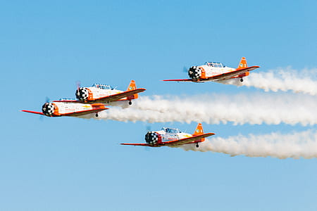 four white-and-orange monoplanes soaring on the sky thumbnail