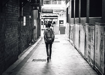 grayscale photo of man standing near McDonalds store thumbnail