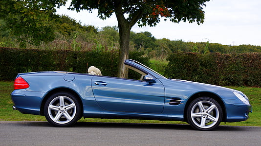 blue Mercedes-Benz convertible coupe parked near green leaf tree thumbnail