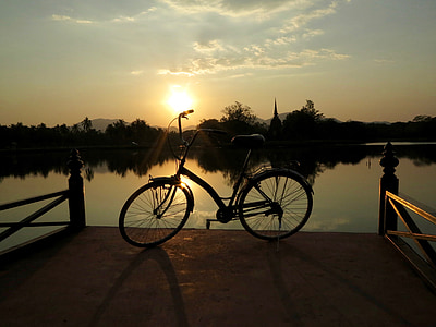 black cruiser bike on dock during golden hour thumbnail