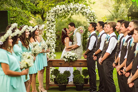 woman and man kissing in front of bridesmaid and groomsmen wedding ceremony thumbnail