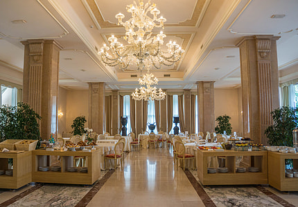 white candelabra chandelier above brown wooden tables thumbnail