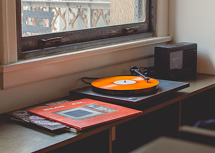 black and orange vinyl player beside clear glass window thumbnail
