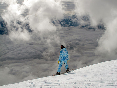 person wearing blue ski uit with board on top of snowy mountain thumbnail