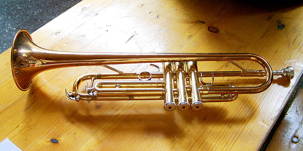 brass trumpet on brown wooden table thumbnail