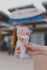 person holding strawberry ice cream in cone thumbnail