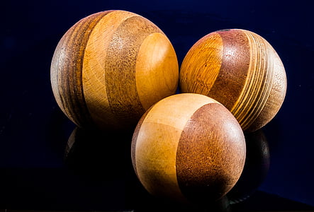three brown croquet balls with black background thumbnail