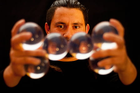 selective focus photography of man holding clear glass balls thumbnail
