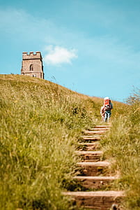 low angle photo of person walking toward to tower at daytime thumbnail