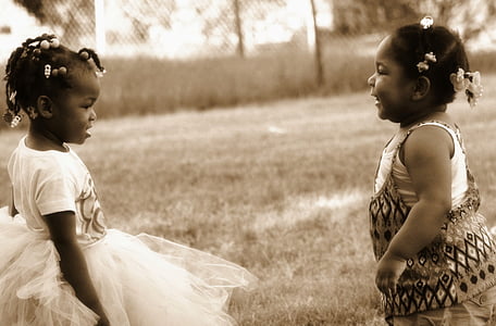 grayscale photo of two girls playing on grass thumbnail