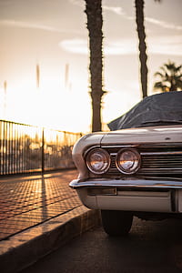 classic white car parked on gray top road during golden hour thumbnail