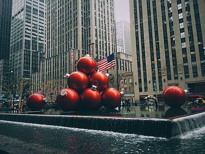 red bauble on body of water near high-rise buildings thumbnail