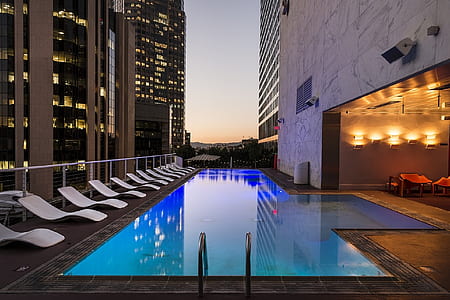 white plastic lounges beside pool thumbnail
