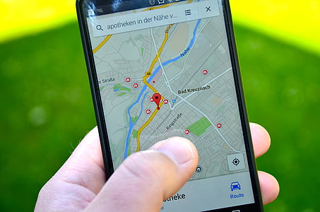 person holding phone displaying GPS map thumbnail