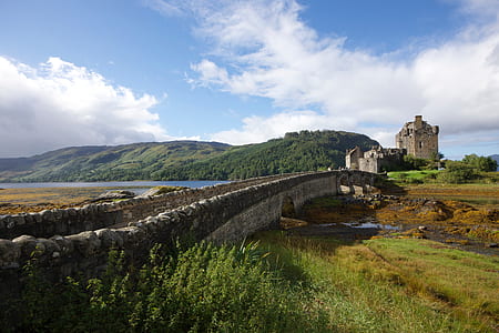 photo of concrete bridge near mountain range and tower thumbnail